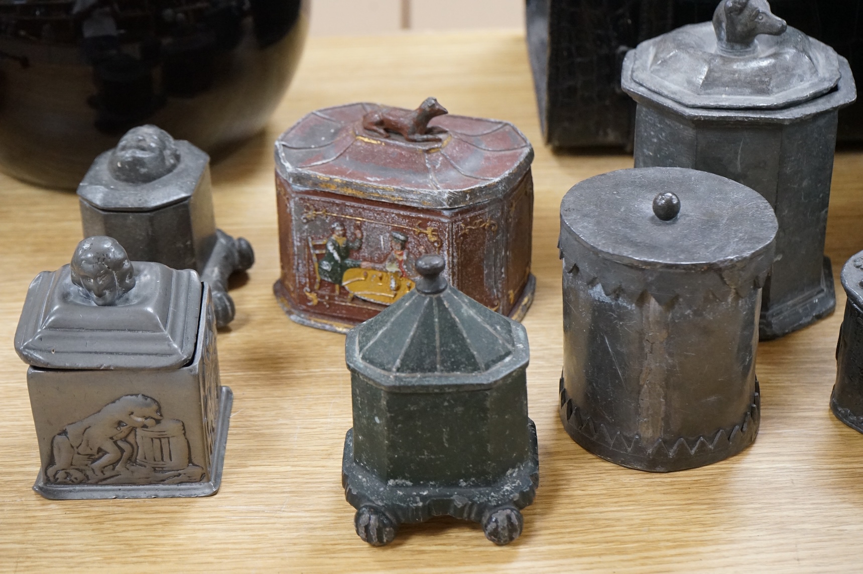 A collection of ten early 19th century lead tobacco boxes, to include an octagonal example, decorated in relief with the remains of red and gilt paint, largest 13cm wide